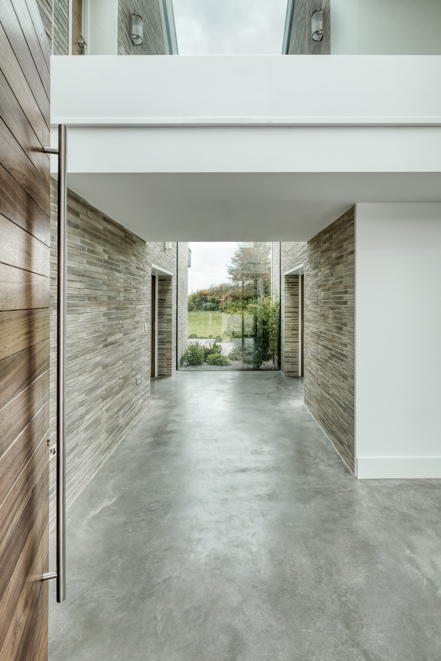 Fully glazed double height hallway new build home interior design